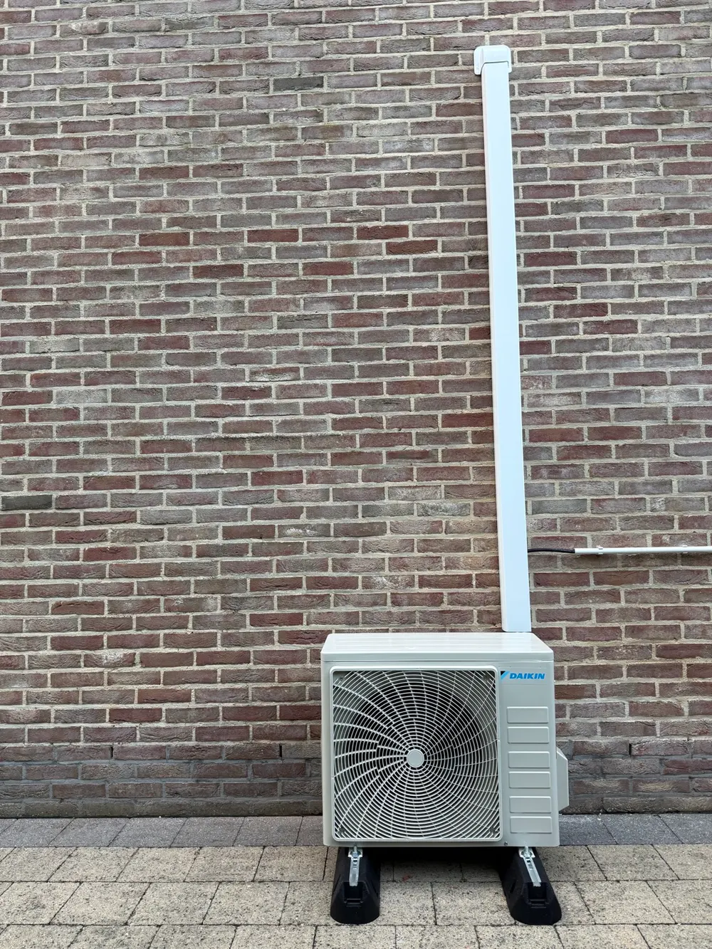 Daikin buitenunit netjes weggewerkt tegen de gevel in Zoerle-Parwijs (Westerlo)